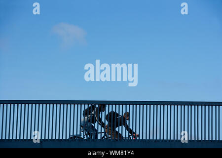 Les navetteurs cyclistes sur une balustrade de bridge Banque D'Images