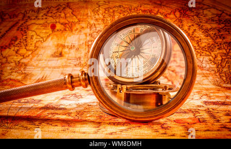 Vintage still life. Vintage loupe se trouve sur une ancienne carte du monde en 1565. Banque D'Images