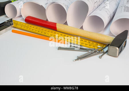 Dimensions rouleaux, marteau, clous, builder, crayon, sur trois carrés de surface blanc Banque D'Images