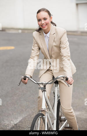 Young businesswoman riding son vélo à l'extérieur de la ville Banque D'Images