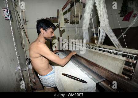 Une soie weaver travaillant dans une petite entreprise à Varanasi, Inde. Banque D'Images