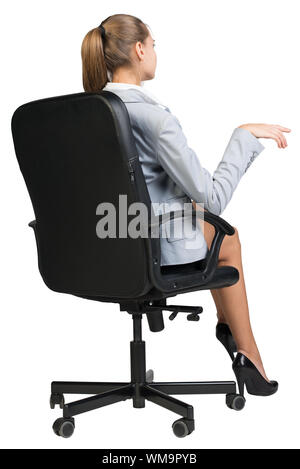 Businesswoman on office chair, demi-tour par derrière, ce geste comme si parler à quelqu'un. Plus isolé sur fond blanc Banque D'Images