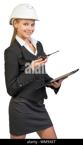 Businesswoman posing in hard hat et lunettes de protection, looking at camera, souriant. Plus isolé sur fond blanc Banque D'Images