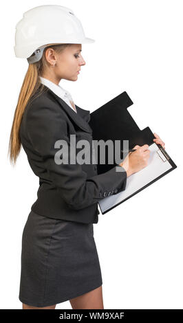 Businesswoman wearing hard hat, l'écriture sur presse-papiers vierges. Plus isolé sur fond blanc Banque D'Images