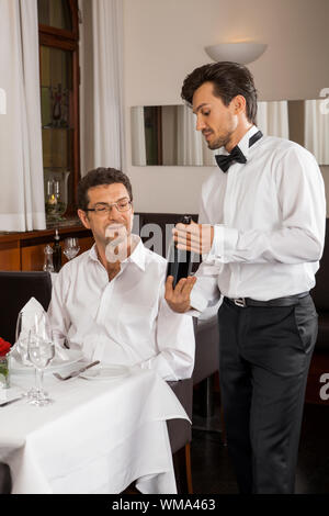 Waiter serving un couple dans un restaurant. Banque D'Images