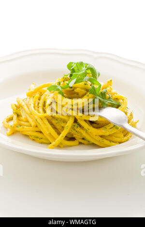 Photo de délicieux plats de pâtes au pesto de roquette et au safran sur fond isolé Banque D'Images