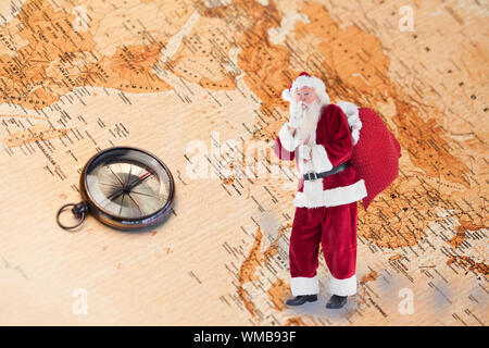 Santa pour demander avec calme contre sac world map with compass showing asie du sud Banque D'Images