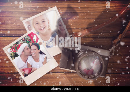 Image composite de souvenirs de Noël contre l'instant photos sur plancher en bois Banque D'Images
