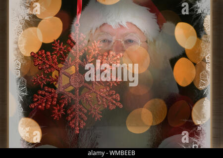 Santa sourit avec bras croisés contre l'accent sur l'étoile rouge de Noël Décoration Banque D'Images