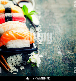 Sushi avec des baguettes sur l'ancien fond de bois Banque D'Images