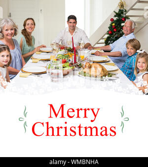 Image composite de family having christmas repas ensemble contre border Banque D'Images