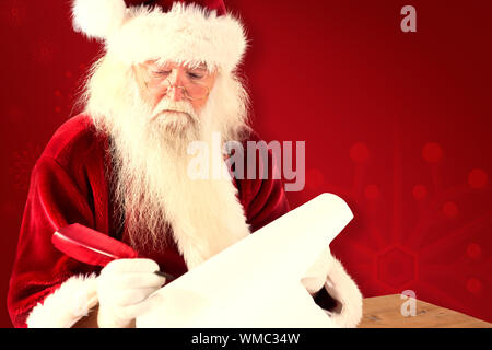 Santa écrit quelque chose avec une plume contre fond rouge Banque D'Images