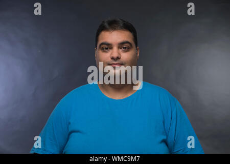 Portrait of smiling fat man sur un fond noir Banque D'Images