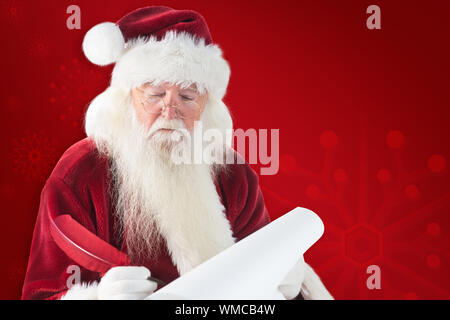 Santa écrit quelque chose avec une plume contre fond rouge Banque D'Images