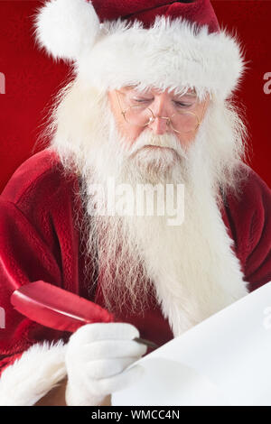 Santa écrit quelque chose avec une plume contre fond rouge Banque D'Images