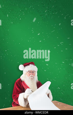 Santa écrit quelque chose avec une plume contre green snowflake background Banque D'Images