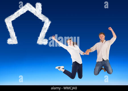 Image composite du couple jumping and holding hands against blue sky Banque D'Images