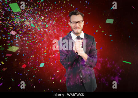 Homme d'Hipster donnant un discours contre l'explosion d'artifices colorés sur fond noir Banque D'Images