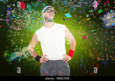 Hipster geek posing in sportswear contre l'explosion d'artifice colorés sur fond noir Banque D'Images