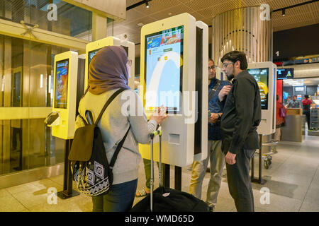 Dubaï, Émirats arabes unis - circa 2019, janvier : les gens utilisent des kiosques de commande chez McDonald's restaurant à l'Aéroport International de Dubaï. Banque D'Images