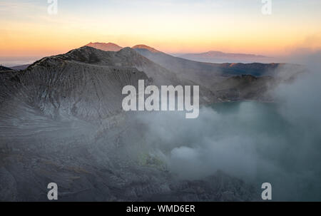 Cratère du volcan Ijen Kaweh dans l'Est de Java, Indonésie volutes de gaz de soufre au lever du soleil Banque D'Images