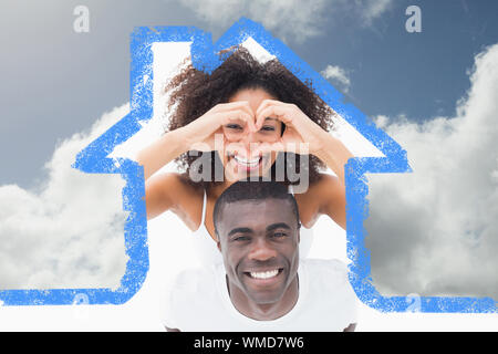 Beau couple de vêtements smiling at camera contre ciel bleu avec des nuages Banque D'Images