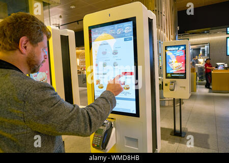 Dubaï, Émirats arabes unis - circa 2019, janvier : Utiliser des bornes de commande chez McDonald's restaurant à l'Aéroport International de Dubaï. Banque D'Images