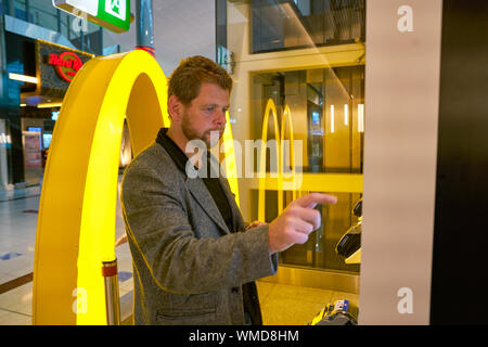 Dubaï, Émirats arabes unis - circa 2019, janvier : Utiliser des bornes de commande chez McDonald's restaurant à l'Aéroport International de Dubaï. Banque D'Images