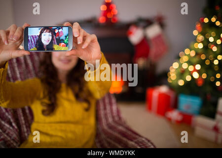 La beauté rousse prenant une à selfies Noël à la maison dans le salon Banque D'Images