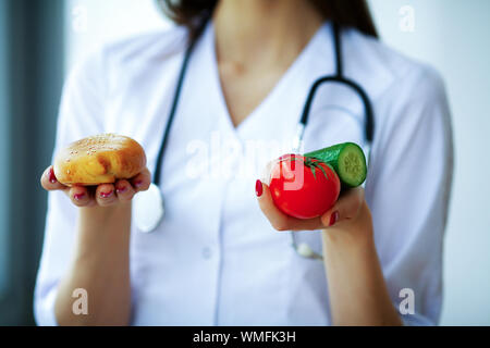 Santé et beauté. La diététiste tient les fruits et légumes frais dans les mains. Jeune docteur avec un beau sourire. Haute résolution Banque D'Images