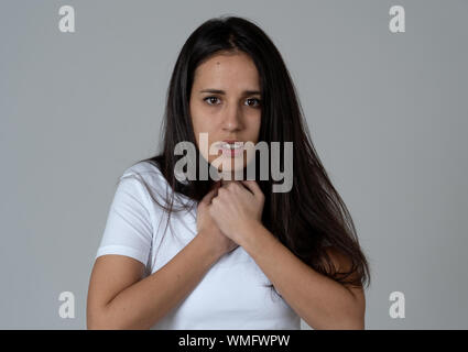 Portrait de jeune femme latine sentiment effrayé et choqué de faire peur, l'anxiété des gestes. Terrifié à la couvrant elle-même. Copier l'espace. En négatif hu Banque D'Images