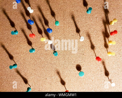 Les punaises multicolores underlit dans un tableau de liège Banque D'Images