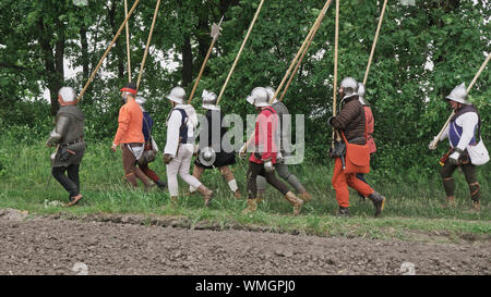 Un groupe de chevaliers médiévaux passe la bataille. Aller avec des lances de guerriers, des épées, des arcs et des casques sur la tête. Banque D'Images