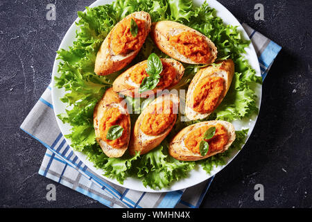 Vue de dessus de la bruschetta grillé avec purée de légumes, purée, caviar de courgettes cuites, tomate, carotte et épices servi sur une plaque blanche sur un conc Banque D'Images