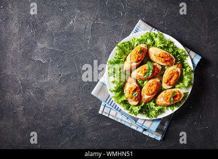 Bruschetta grillé avec purée de légumes, purée, caviar de courgettes cuites, tomate, carotte et épices servi sur une plaque blanche sur une table, la vue Banque D'Images