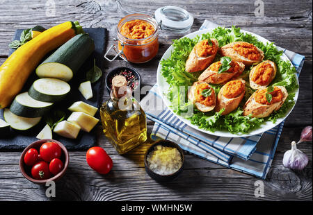 Baguette grillées avec purée de légumes, purée, caviar de courgettes cuites, tomate, carotte et épices servi sur une plaque blanche sur une table en bois rustique, cl Banque D'Images