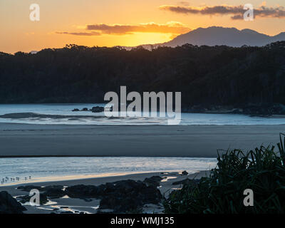 Soleil doré derrière les collines au bord de la mer au début du printemps, Australie Banque D'Images