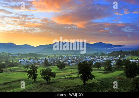 L'Anhui, Anhui, Chine. 12Th Mar, 2019. Anhui, Chine-une vue splendide de nuages est pris dans le comté de Yixian, dans la province de Anhui, le matin du 5 septembre 2019.ce jour, tôt le matin du comté de Yixian, dans la province de Anhui, le soleil se lève peu à peu, l'horizon est rouge et jaune progressivement la couleur, nuage nuages changer des milliers d, avec des montagnes, des champs et des maisons populaires reflètent mutuellement, constituent un magnifique cadre rural photo défiler. Crédit : SIPA Asie/ZUMA/Alamy Fil Live News Banque D'Images