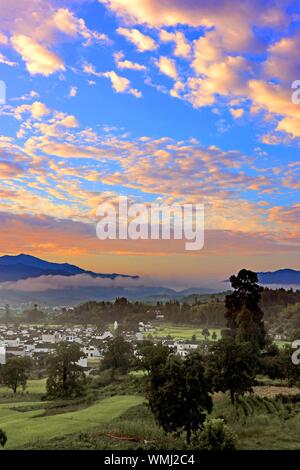 L'Anhui, Anhui, Chine. 12Th Mar, 2019. Anhui, Chine-une vue splendide de nuages est pris dans le comté de Yixian, dans la province de Anhui, le matin du 5 septembre 2019.ce jour, tôt le matin du comté de Yixian, dans la province de Anhui, le soleil se lève peu à peu, l'horizon est rouge et jaune progressivement la couleur, nuage nuages changer des milliers d, avec des montagnes, des champs et des maisons populaires reflètent mutuellement, constituent un magnifique cadre rural photo défiler. Crédit : SIPA Asie/ZUMA/Alamy Fil Live News Banque D'Images