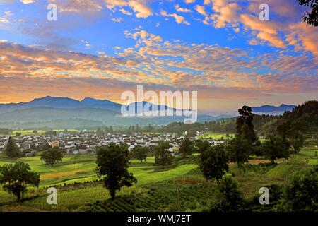 L'Anhui, Anhui, Chine. 12Th Mar, 2019. Anhui, Chine-une vue splendide de nuages est pris dans le comté de Yixian, dans la province de Anhui, le matin du 5 septembre 2019.ce jour, tôt le matin du comté de Yixian, dans la province de Anhui, le soleil se lève peu à peu, l'horizon est rouge et jaune progressivement la couleur, nuage nuages changer des milliers d, avec des montagnes, des champs et des maisons populaires reflètent mutuellement, constituent un magnifique cadre rural photo défiler. Crédit : SIPA Asie/ZUMA/Alamy Fil Live News Banque D'Images