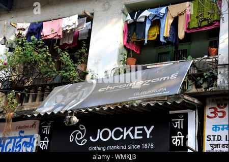 Mumbai, Maharashtra, Inde, Asie du Sud-Est - Chiffons colorés accroché pour sécher à l'ancien bâtiment du toit de boue Chawl, PAREL. Banque D'Images