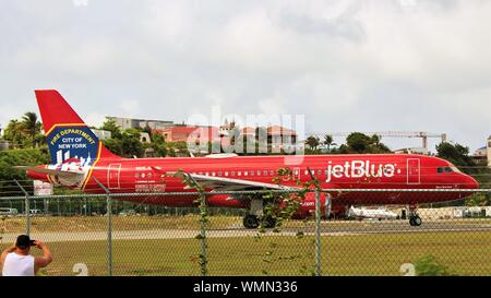 L'Airbus A320 de jetBlue avec le FDNY livrée, s'aligne sur la piste comme il se prépare à décoller de l'Aéroport Princess Juliana, St Maarten. Banque D'Images