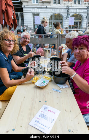 Lille,FRANCE-septembre 01,2019 : Grande Braderie de Lille (Braderie de Lille).Les gens heureux plat traditionnel de l'alimentation sur Lille Braderie,des moules et des frites. Banque D'Images