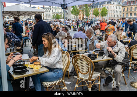 Lille,FRANCE-septembre 01,2019 : Grande Braderie de Lille (Braderie de Lille).Les gens heureux plat traditionnel de l'alimentation sur Lille Braderie,des moules et des frites. Banque D'Images