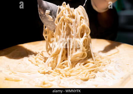 Chef de la cuisson des pâtes dans un bol de fromage Banque D'Images