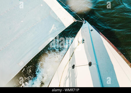 Une barque blanche passe par quelques vagues sur un jour venteux Banque D'Images