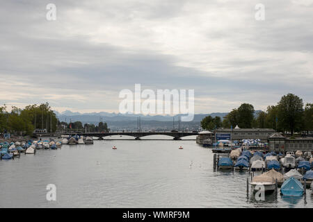 Un jour nuageux à Zürich, Suisse, dans la ligne de la rivière Limmat, vers le pont Quaibrücke, le lac de Zurich et les Alpes. Banque D'Images