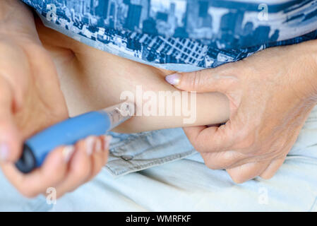 Femme âgée s'offre contre l'ostéoporose d'injection dans l'abdomen.Traitement du diabète dans une population. Les femmes âgées vieux stylo injecteur utilisé.Femmes faire des injections dans l'estomac avec stylo injecteur. Banque D'Images