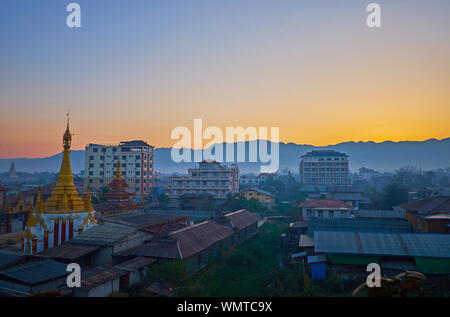 Tôt le matin dans la région de Nyaungshwe village touristique, le soleil se cache derrière les silhouettes des montagnes sombres, au Myanmar. Banque D'Images