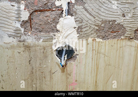 Nouvelle installation électrique dans un mur pour une prise de courant pendant les travaux de reconstruction dans un appartement Banque D'Images